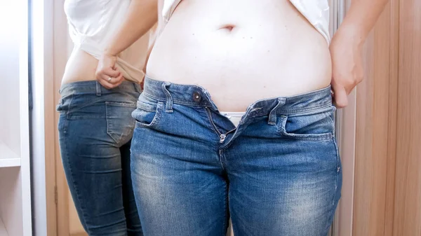 Foto close-up de mulher com sobrepeso cabendo em jeans apertados no camarim — Fotografia de Stock