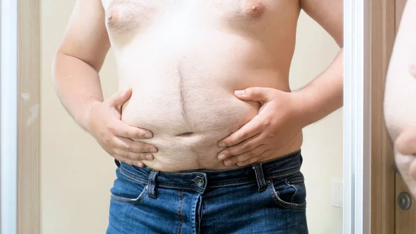 Ung bar överkropp man med stor fet mage stående spegel — Stockfoto