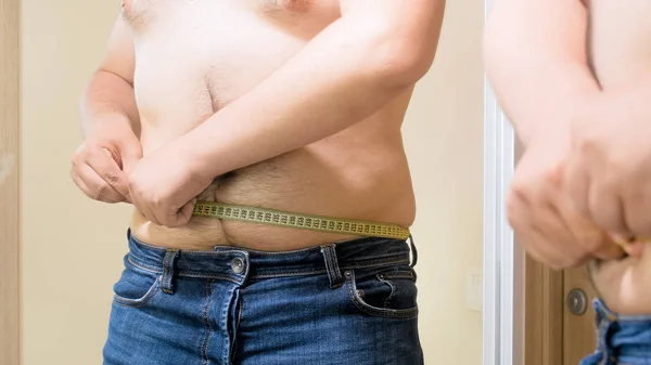 Detailní Foto obézní muž v džínách s krejčovským metrem — Stock fotografie