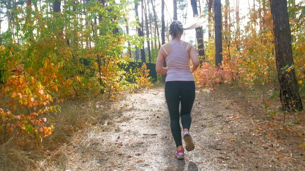 Rear view photo of young owman running in forest at bright sunny day — Stock Photo, Image