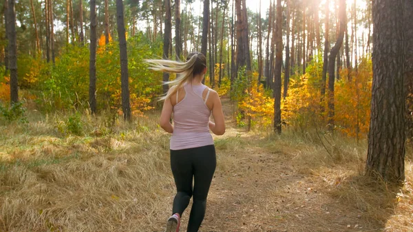 Visão traseira foto de jovem coruja em leggings correndo na floresta de outono — Fotografia de Stock