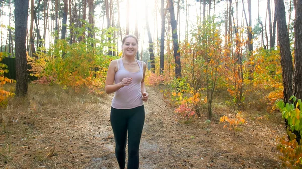 Porträt einer jungen sportlichen Frau, die im Herbstwald turnt — Stockfoto
