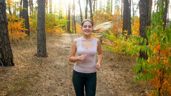 Portret van lachende mooie vrouw joggen in bossen op ochtend toned — Stockfoto