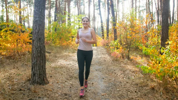 Beautiful slim woman jogging in park at bright sunny morning — Stock Photo, Image