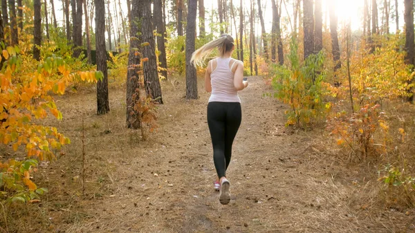 Sexy slim woman in sport legging running in park at bright sunny morning — Stock Photo, Image