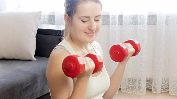Closeup portrait of active housewife exercising with dumbbells at home — Stock Photo, Image