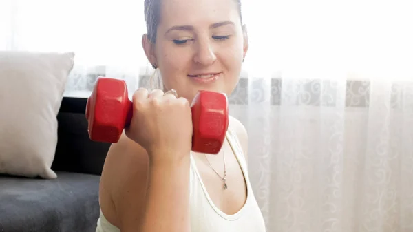 Closeup photo of young woman holding red dumbbell — Stock Photo, Image