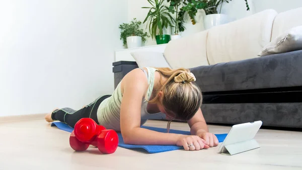 Młoda Blondynka relaks po ćwiczeń fitness aplikacji na tablet — Zdjęcie stockowe