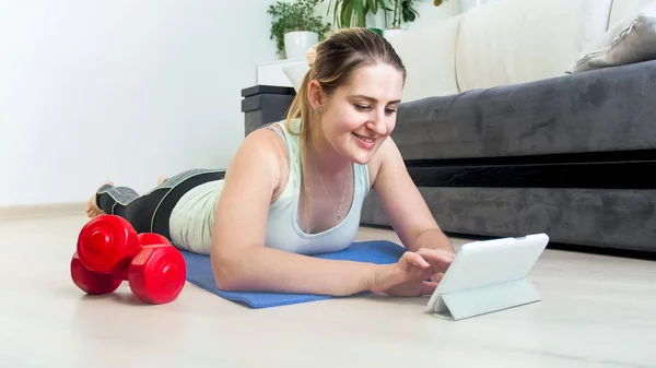 Mooie jonge vrouw, surfen op internet op tablet na het doen van oefeningen — Stockfoto