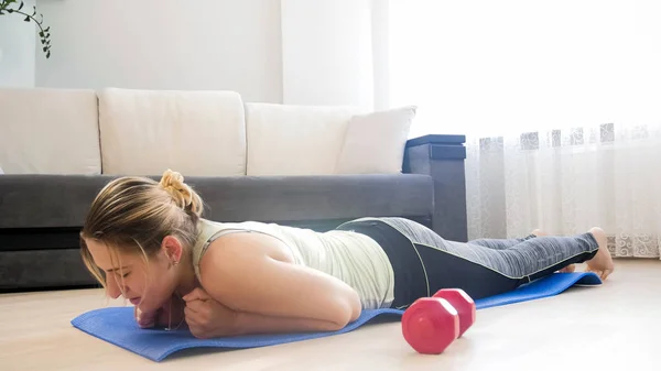 Young woman fell on floor after doing plank exercise — Stock Photo, Image