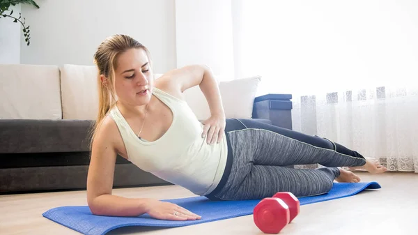 Ung kvinna utövar på fitness mat hemma — Stockfoto