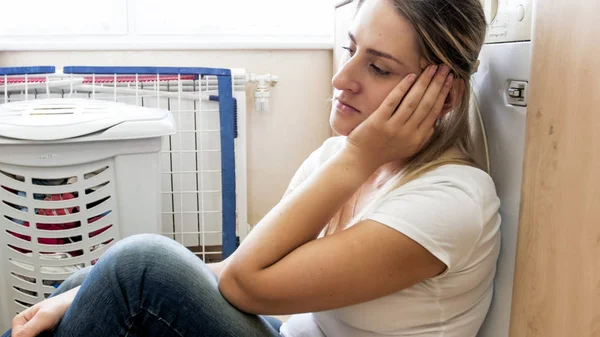 Portret van depressieve jonge vrouw achter Wasserij — Stockfoto