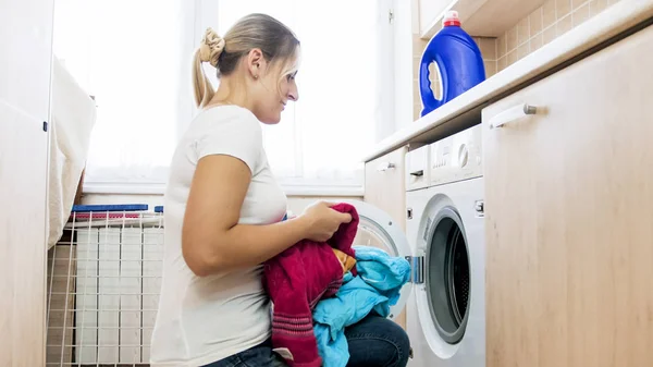 Beautiful blonde housewife loading washing machine — Stock Photo, Image