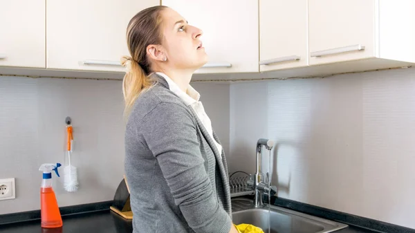 Retrato de la agotada joven ama de casa de pie en la cocina — Foto de Stock