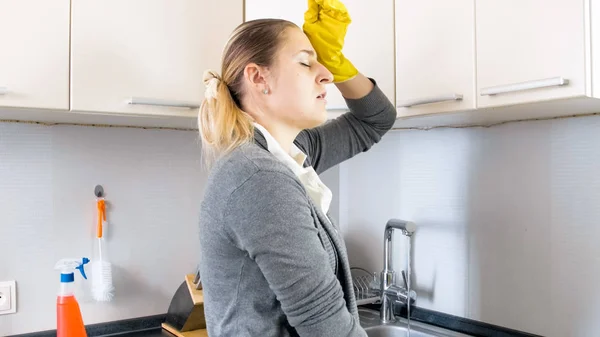 Retrato de jovem dona de casa cansada limpando o suor da testa — Fotografia de Stock