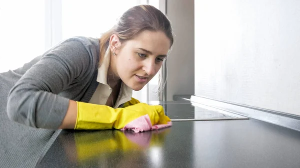 Portrait of young housewife cleaning dirty countertop — Stock Photo, Image