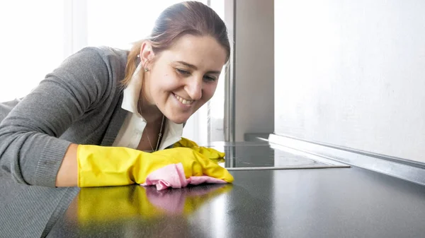 부엌 싱크대를 청소 하는 웃는 젊은 여자의 근접 촬영 사진 — 스톡 사진