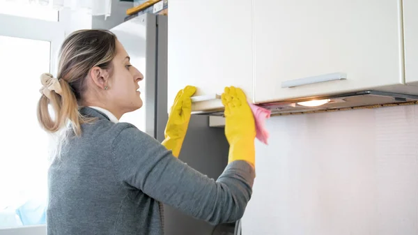 Beautiful young woman washing kitchen with cloth — Stock Photo, Image