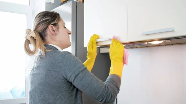 Крупним планом фото молодої жінки, полірування металевих ручок на кухонних шафах — стокове фото