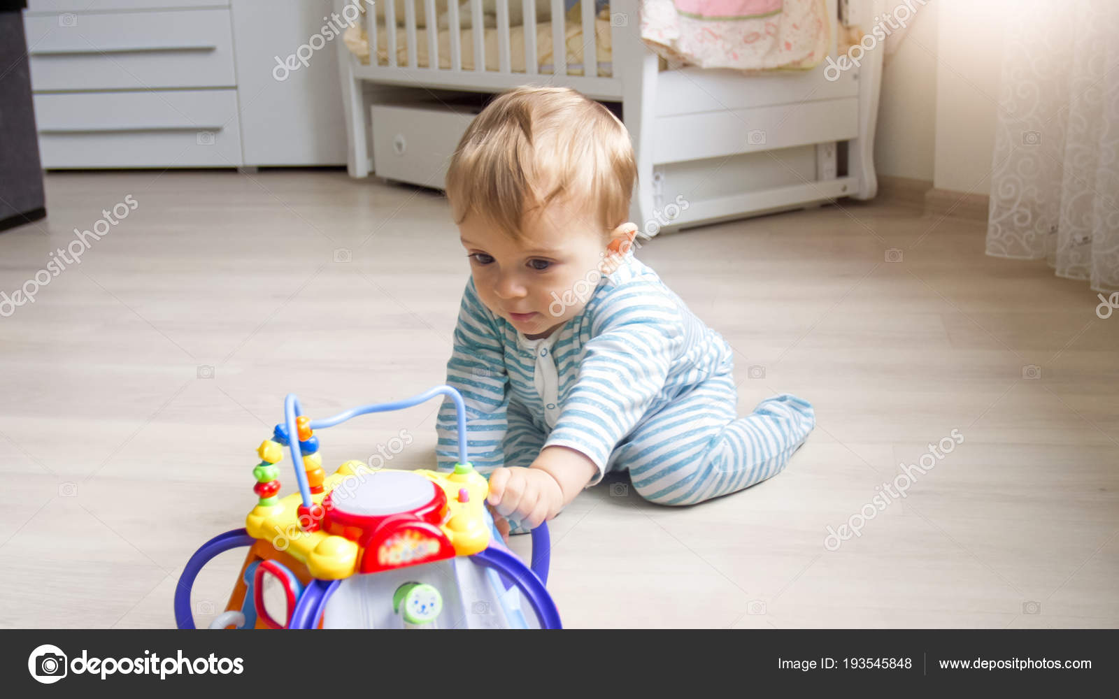 Cute 1 Year Old Toddler Boy Sitting On Floor At Bedroom And
