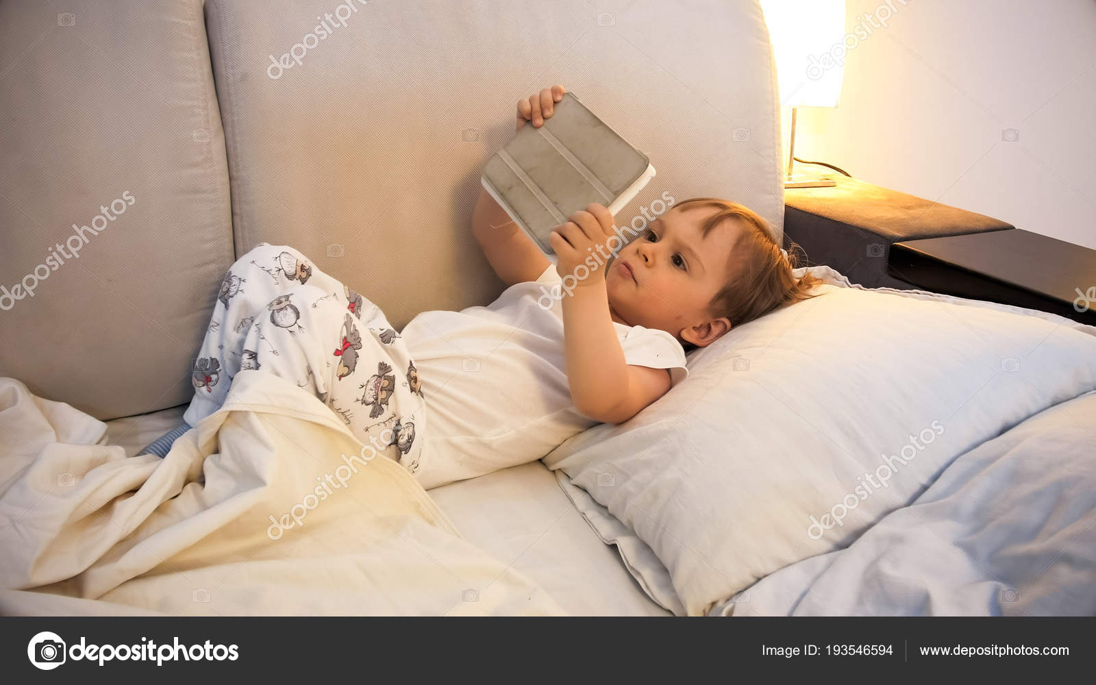 Portrait Of Cute Toddler Boy With Digital Tablet Lying In