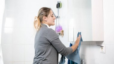 Genç ev hanımı Temizleme banyo aynada lekeli portresi