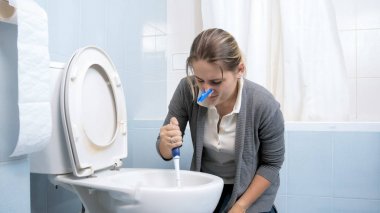 Genç esmer kadın yıkama tuvalet fırçası ile portresi