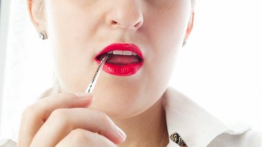 Closeup izole gözlük kulaklık ağzına tutan genç seksi kadın fotoğrafı