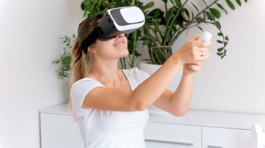 Mutlu genç kadın oyun kumandası tutarak ve video oyunları oynarken Vr kulaklık