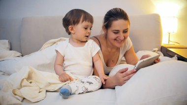 İnternet üzerinde dijital tablet geceleri tarama yürümeye başlayan çocuk oğlu ile gülümseyen güzel annem