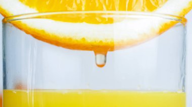 Bardak taze portakal suyu ile düşen damlacık görüntüsünü makro