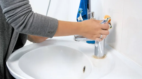 Imagen de primer plano de la mujer lavando grifos de agua de metal en el baño —  Fotos de Stock
