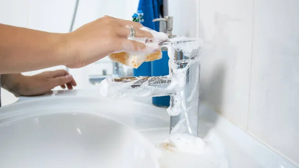 Zbliżenie zdjęcie młodej kobiecie wody z kranu z gąbki do mycia — Zdjęcie stockowe