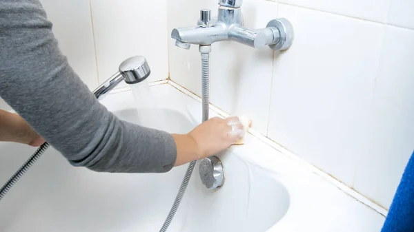 Imagen de primer plano de la mujer joven lavando el baño de tierra con detergente —  Fotos de Stock