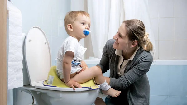 Hermosa madre joven sentada junto a su niño en el baño — Foto de Stock