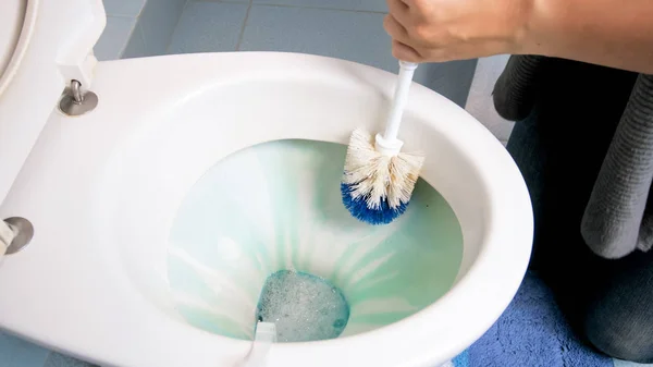 Imagem de close-up da jovem mulher limpando banheiro com escova — Fotografia de Stock