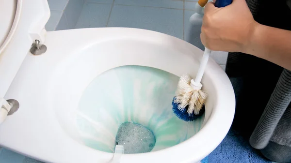 Imagem de close-up da jovem mulher segurando escova para limpar o banheiro — Fotografia de Stock