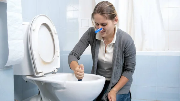 Retrato de jovem morena lavando sujo vaso sanitário manchado — Fotografia de Stock