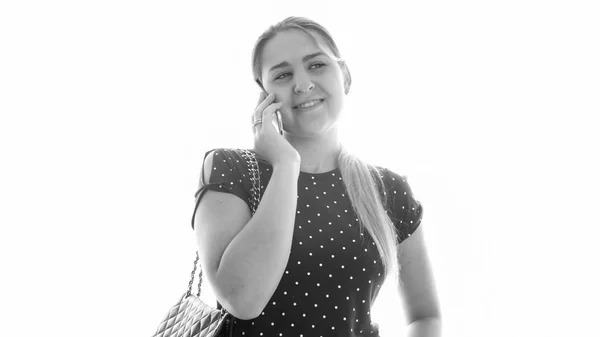 휴대 전화로 이야기 하는 젊은 웃는 여자의 흑백 초상화 — 스톡 사진