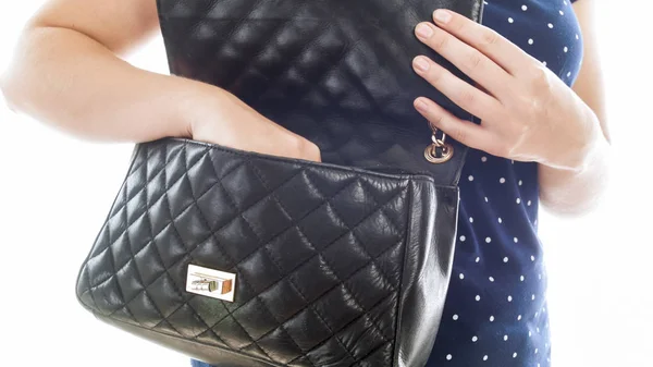 Closeup isolated photo of young woman taking something out of black leather handbag — Stock Photo, Image