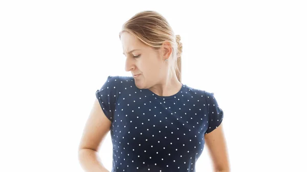 Изолированный портрет молодой женщины, чувствующей неприятный запах от своей футболки — стоковое фото
