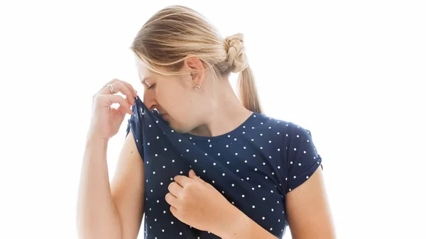 Retrato isolado de jovem loira cheirando sua camiseta — Fotografia de Stock