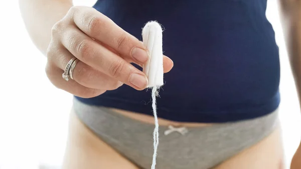Geïsoleerde macro opname van jonge vrouw tampon in handen houden. Concept van vrouwelijke gezondheidszorg — Stockfoto