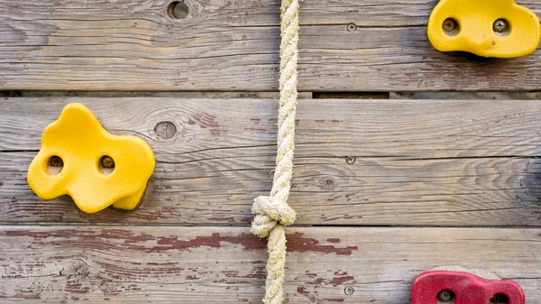 Imagen de cerca de la cuerda y las rocas para escalar en la pared de madera —  Fotos de Stock