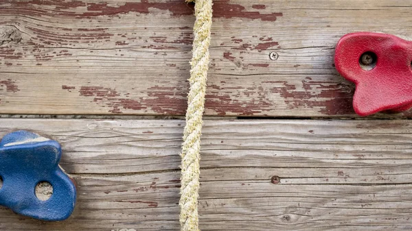 Imagem de close-up de parede de madeira com corda e pedras para escalar no parque infantil — Fotografia de Stock