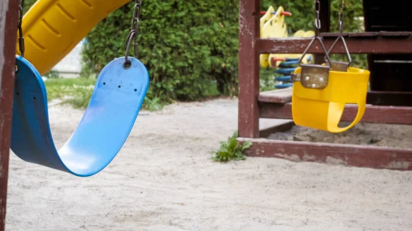 Closeup image of swings on empty children playground — Stock Photo, Image
