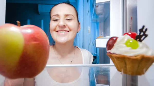Visa från insidan kylskåp av ung kvinna tittar på mat i kylskåp — Stockfoto