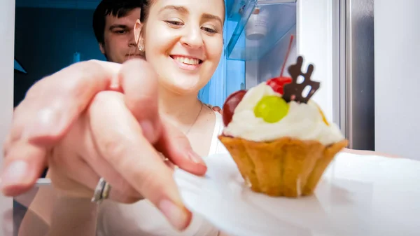 Closeup image of husband stops his wife from eating cake at night — Stock Photo, Image