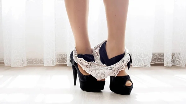 Closeup image of sexy lace panties fell on girl feet in high heels shoes — Stock Photo, Image