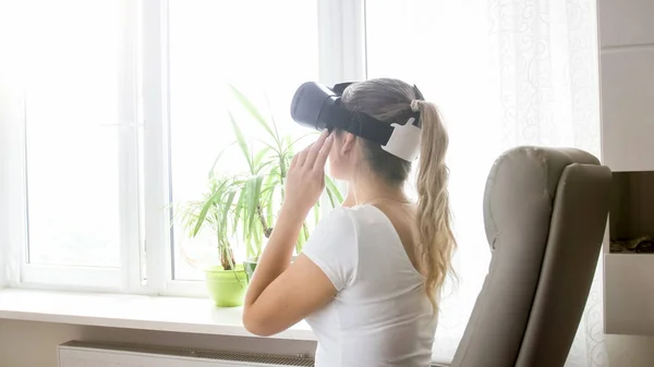 Vista trasera de la foto de una mujer joven con auriculares de realidad virtual — Foto de Stock